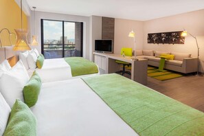 A hotel room with two beds, a desk, a television, and a city view. - TRYP by Wyndham Bucaramanga Cabecera (Bucaramanga)