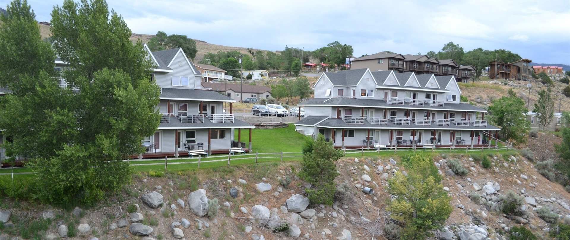 A multi-story hotel with a central courtyard, surrounded by rocky terrain and greenery.