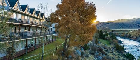 A hotel with a long, covered outdoor area and a view of a river.