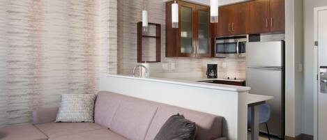 Una cocina moderna con armarios de madera, un refrigerador de acero inoxidable y un microondas integrado.