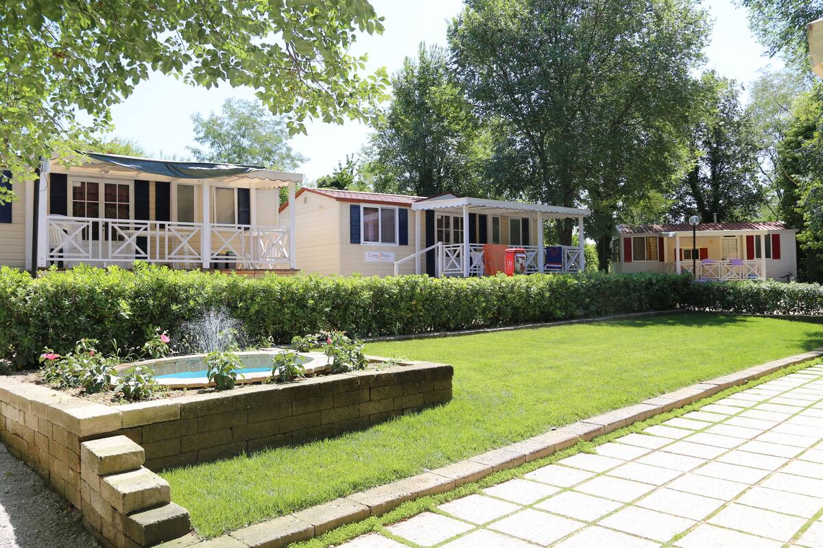 A row of mobile homes with a small pool and a well-maintained lawn.