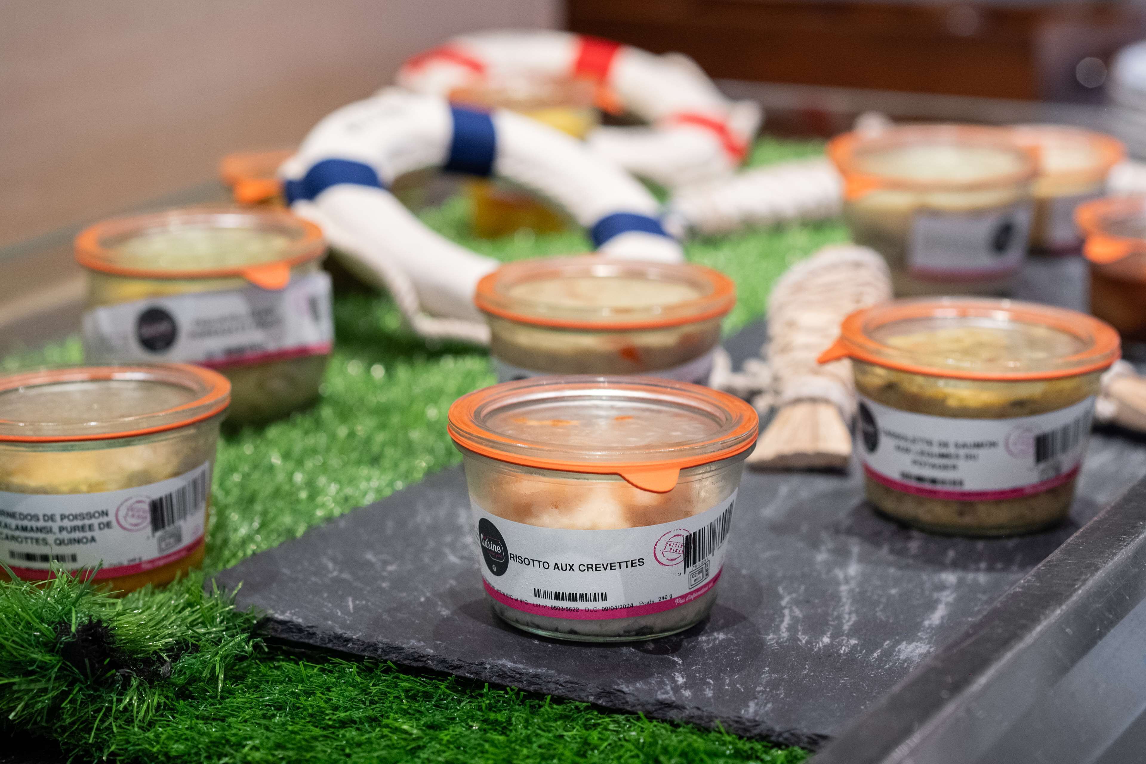 Jars of preserved food on a slate surface with green grass underneath.