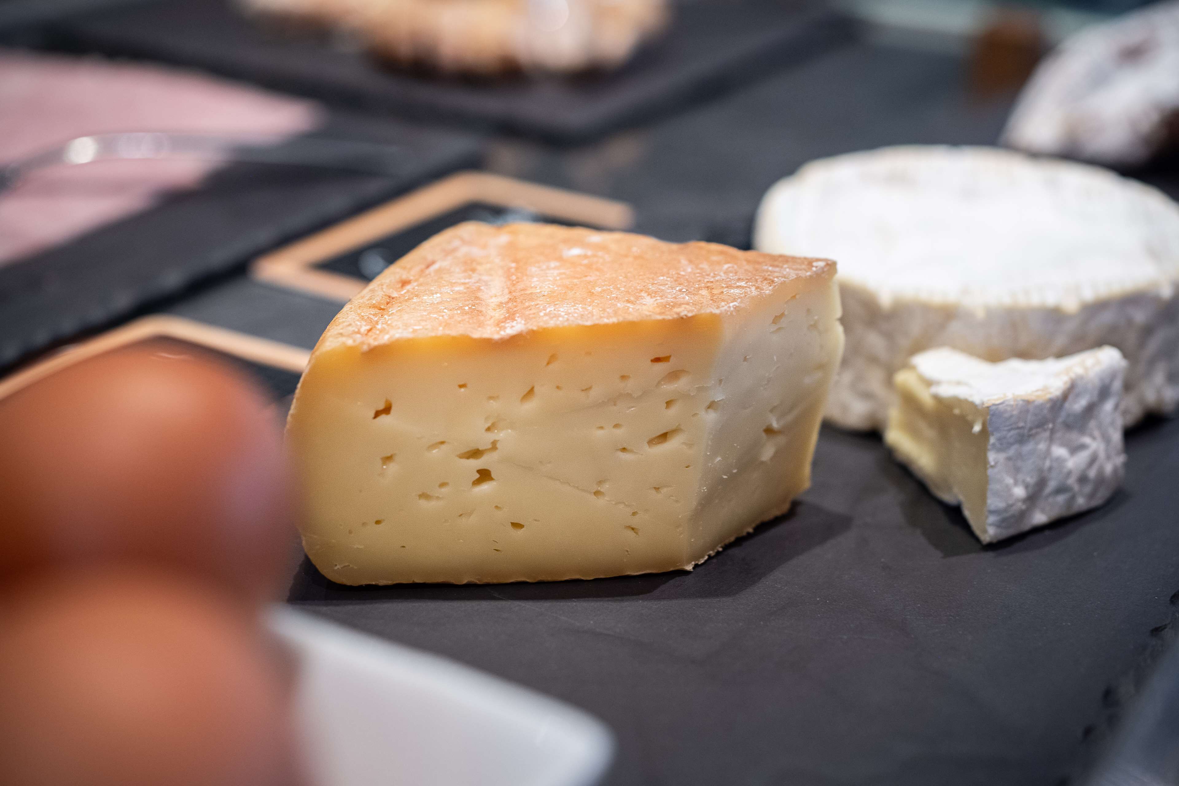 A selection of cheeses on a slate board.