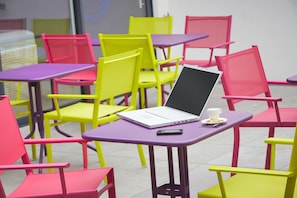 Relax in a stylish seating area with comfortable chairs and tables, perfect for working or socializing.