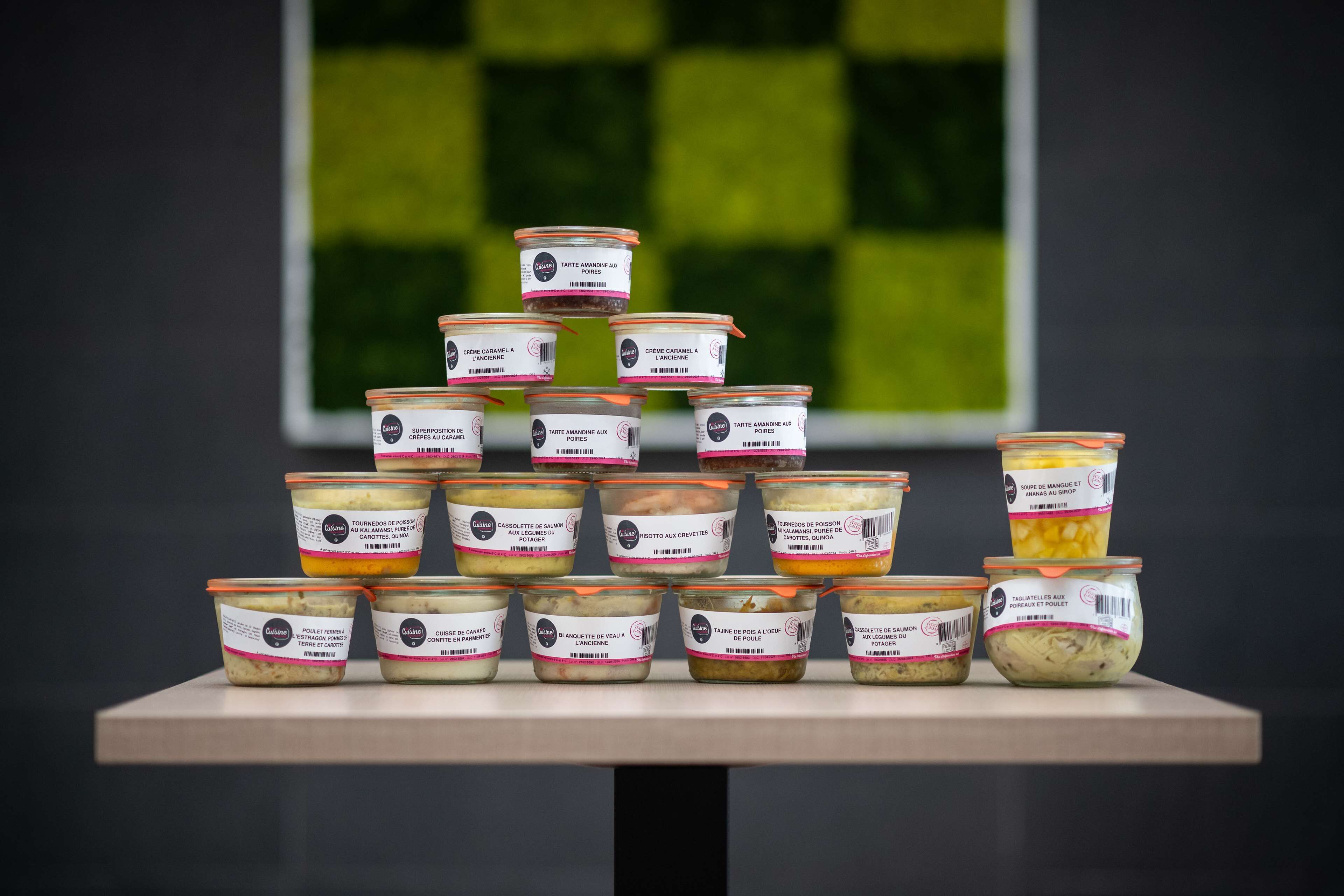 A display of various food containers arranged in a pyramid on a table.