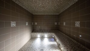 Un baño moderno con piso y techo moteados, que incluye una lámpara central.