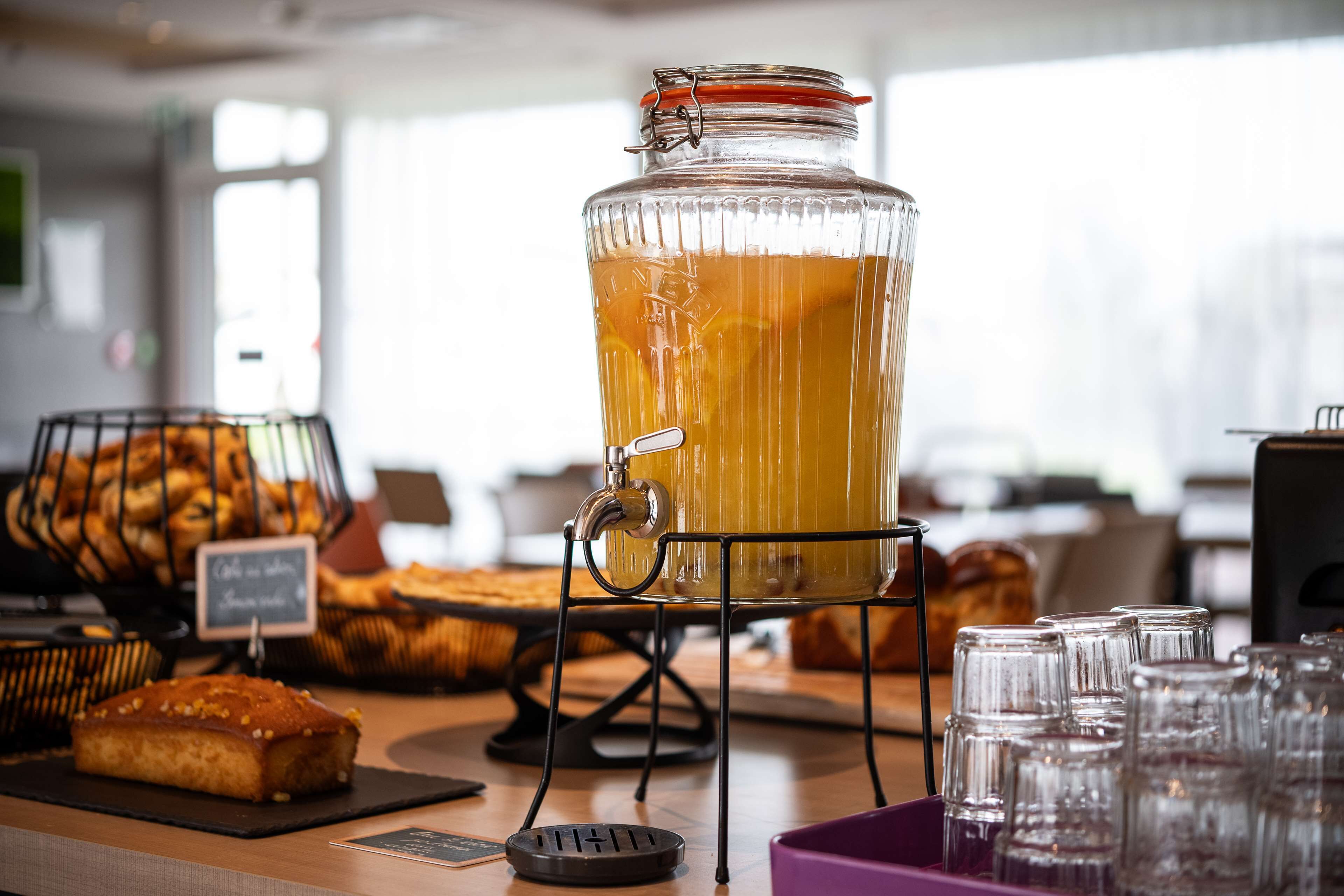 A buffet setup with a large glass punch bowl, bread baskets, and a sign indicating the availability of coffee and tea.