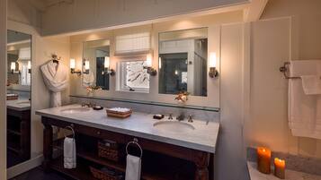 A bathroom with a double sink vanity, large mirrors, and a wooden cabinet below.