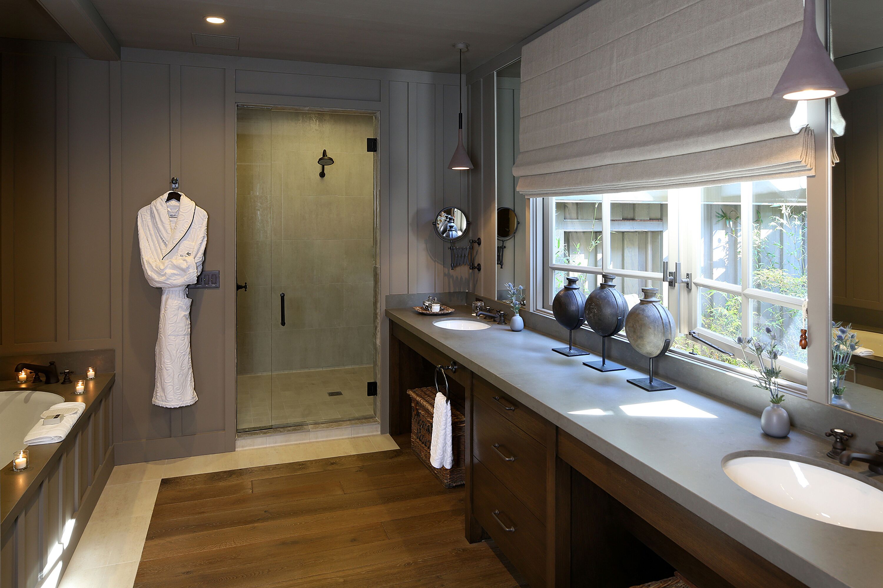 A modern bathroom with a large sink, vanity, and a walk-in shower.
