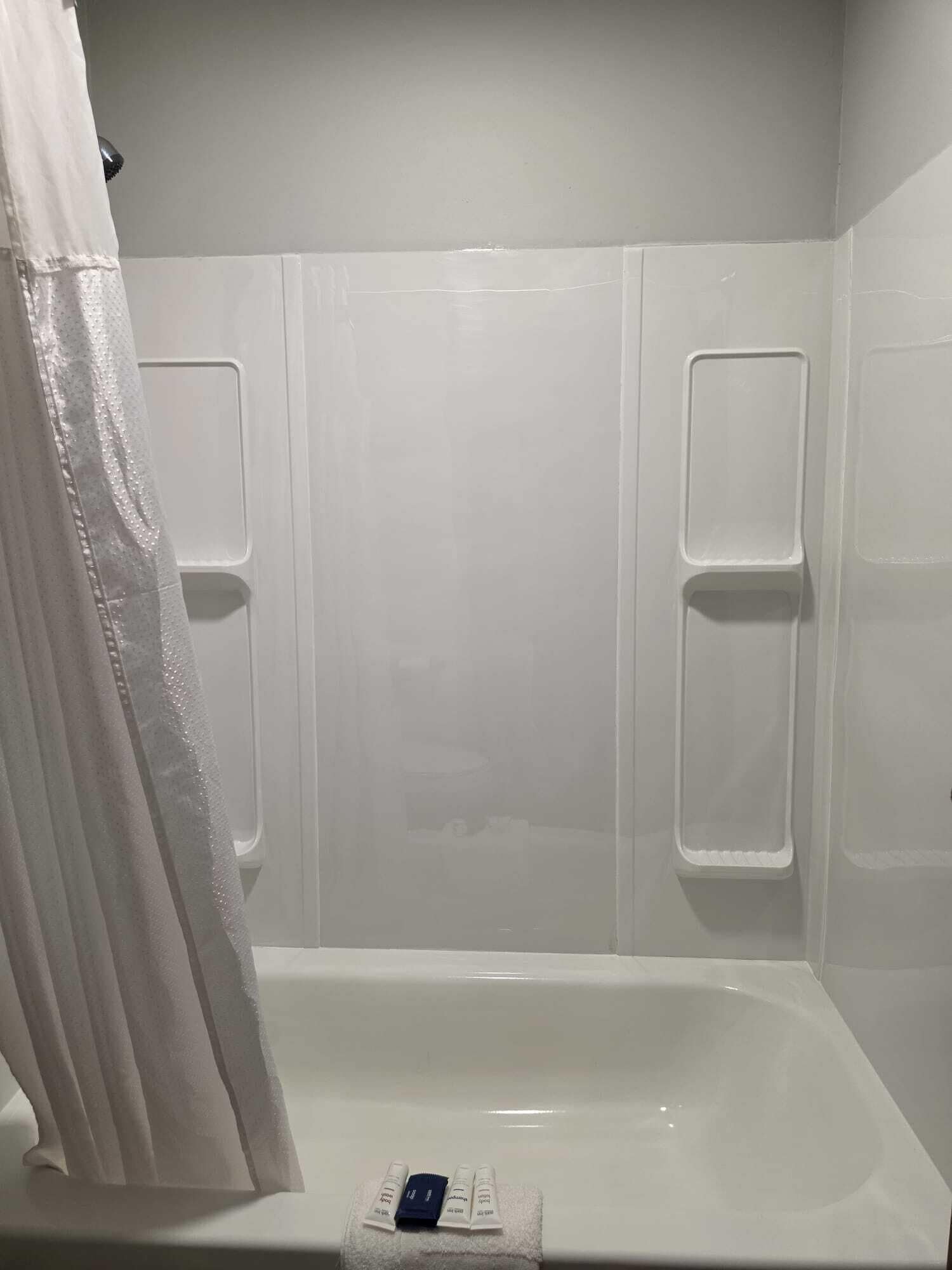 A bathroom with a bathtub, a shower curtain, and a towel rack.