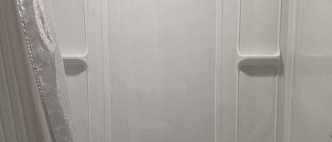 A bathroom with a bathtub, a shower curtain, and a towel rack.