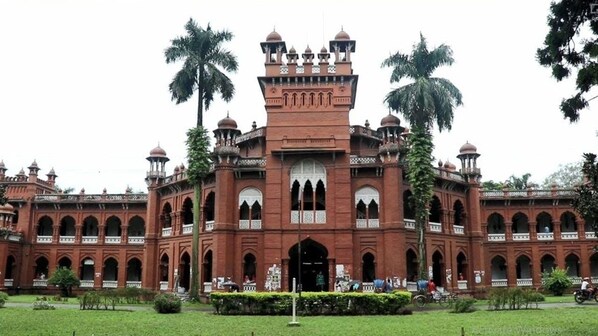 A large, red-brick building with multiple arched windows and a central tower.