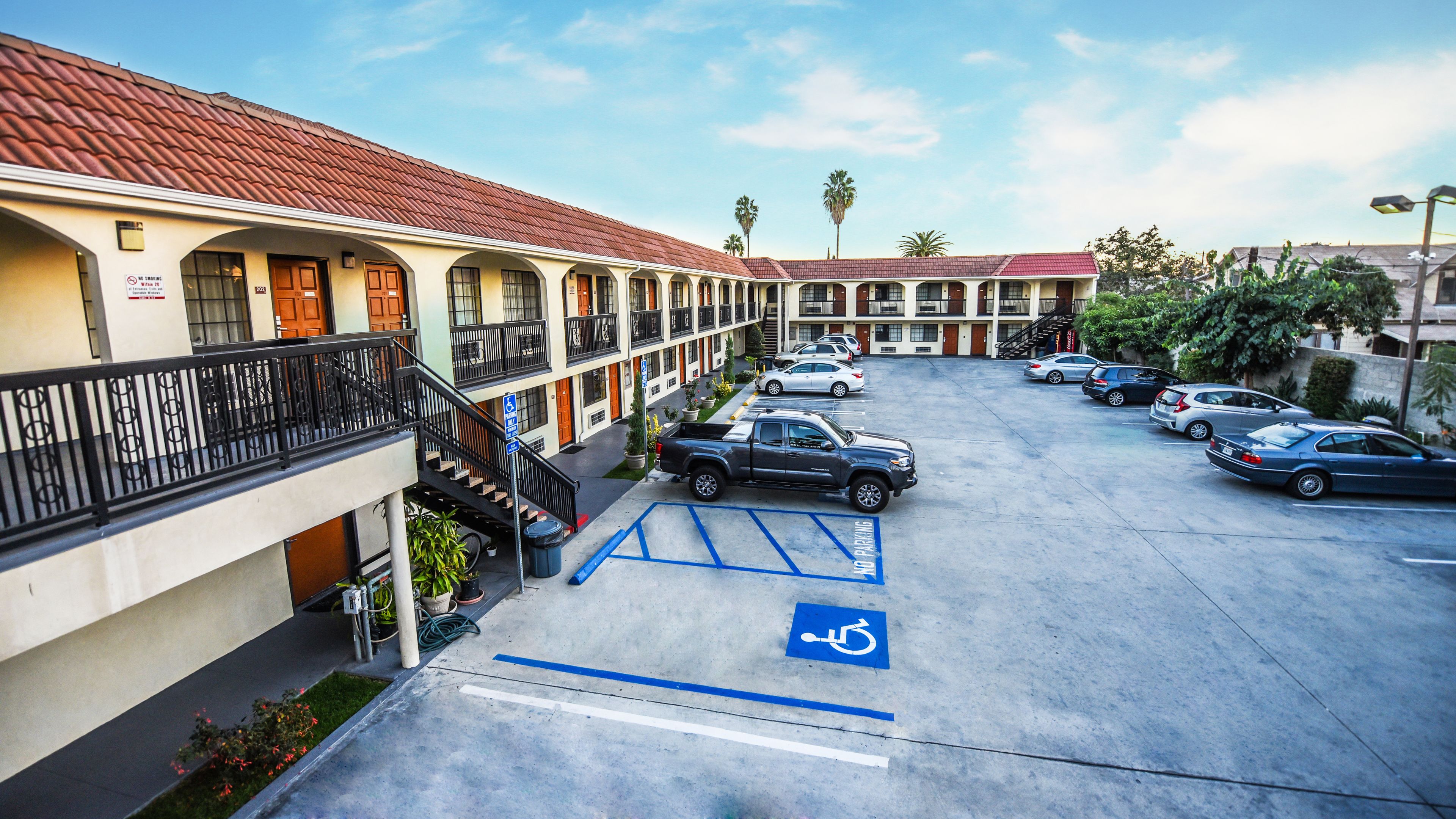 A multi-story motel with a parking lot, including a handicapped parking space.