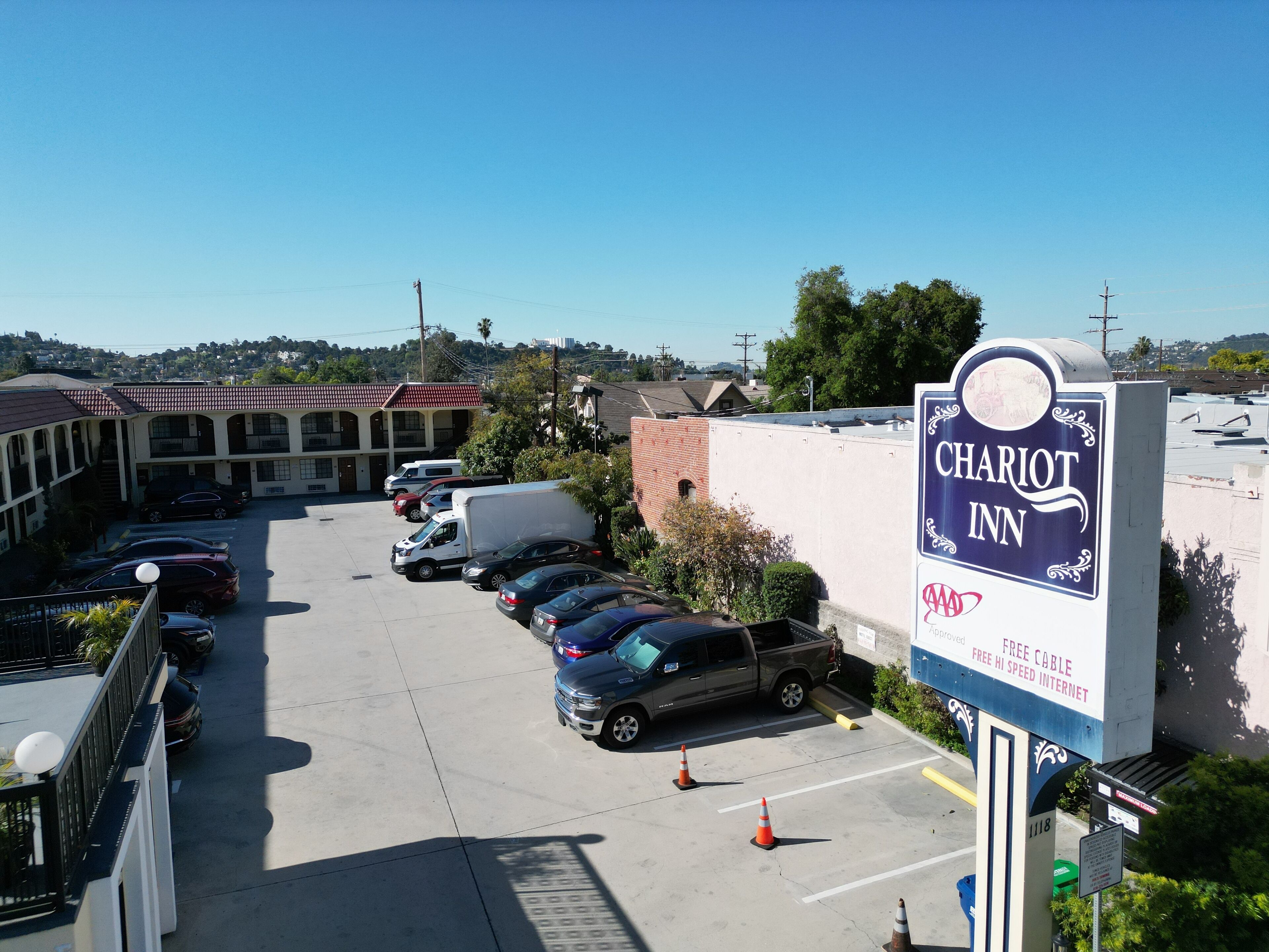 Un estacionamiento con varios coches y un cartel de Chariot Inn.