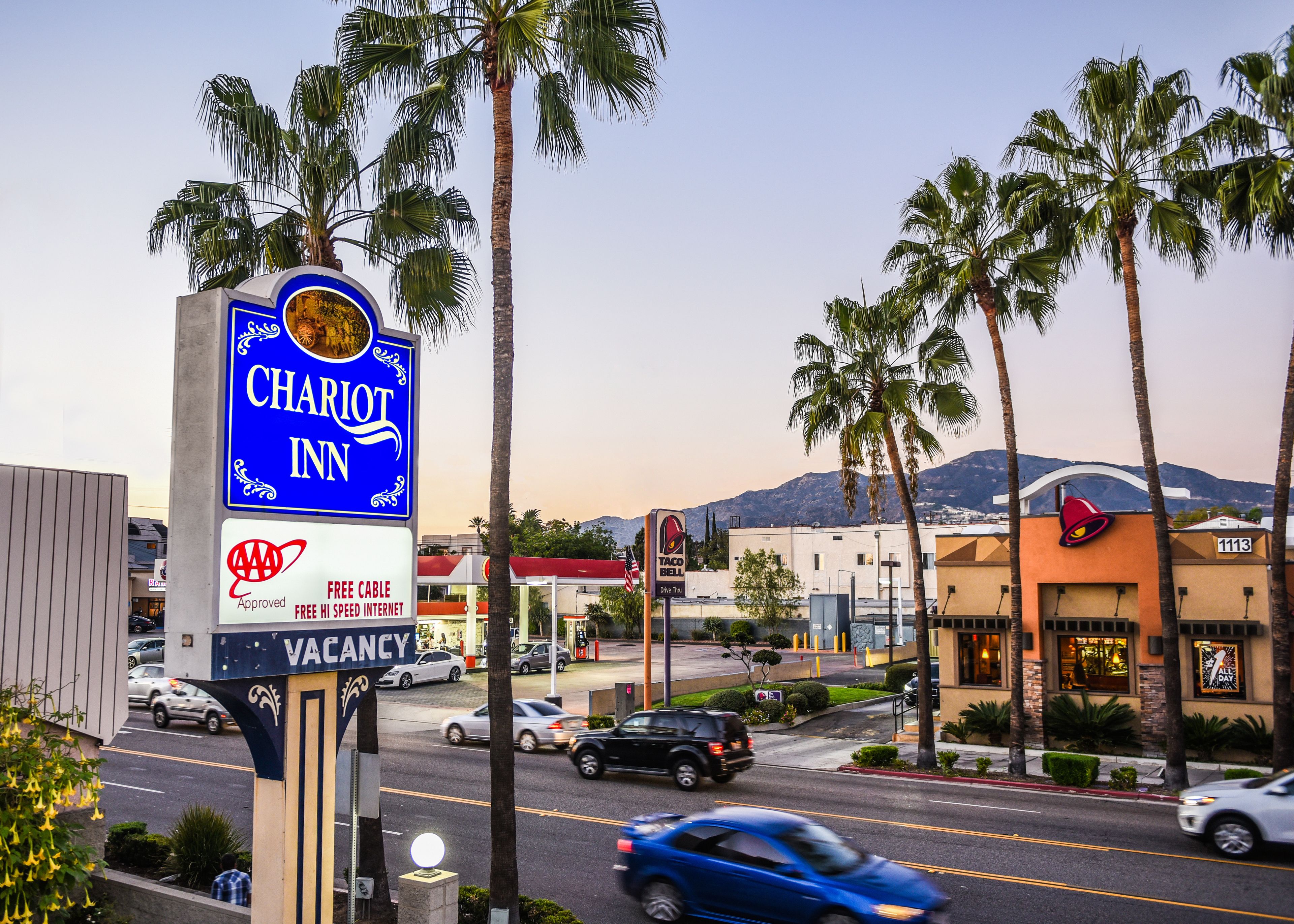 A hotel sign with a mountain view in the background.