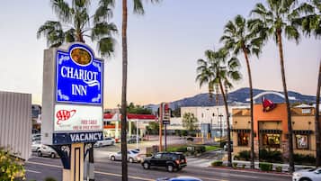 A hotel sign with a mountain view in the background.