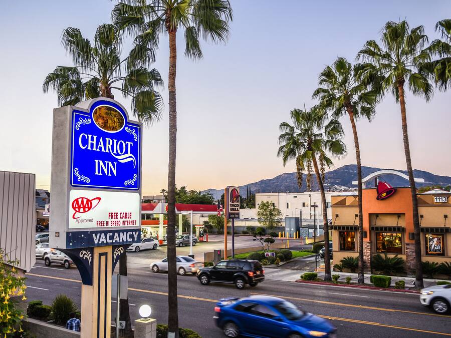 A hotel sign with a mountain view in the background.
