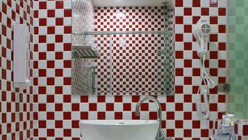 A bathroom with a white sink, a mirror, and a red and white checkered wall.