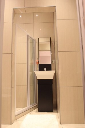 A modern bathroom with a glass shower enclosure, a black sink, and a mirror. - Nauntons Guest House (Ladysmith)