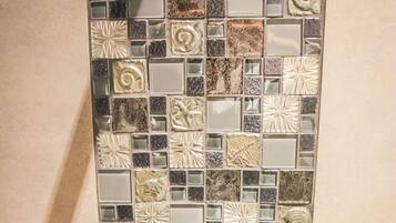 Un baño con un salpicadero de mosaicos y un grifo moderno.