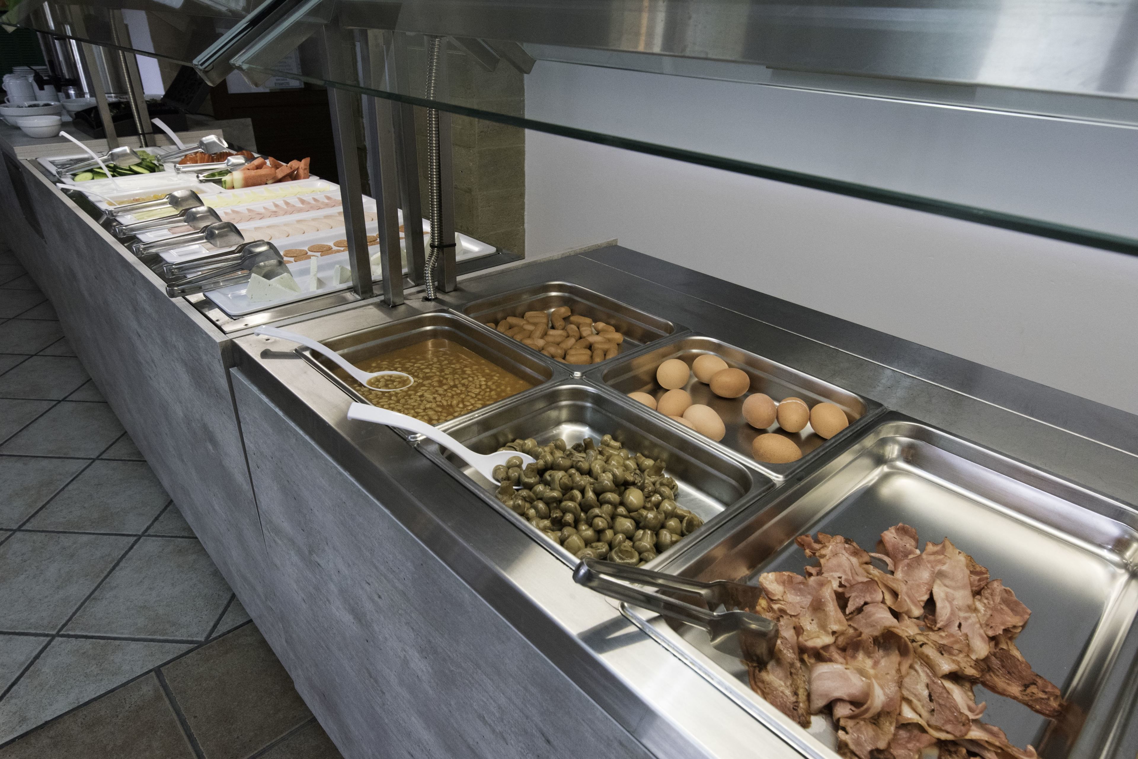 Un bufé con diversos alimentos, como huevos, carne y verduras.