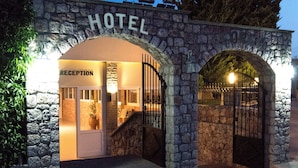 Un arco de piedra con la palabra 'HOTEL' en la parte superior, que da paso a una zona de recepción.