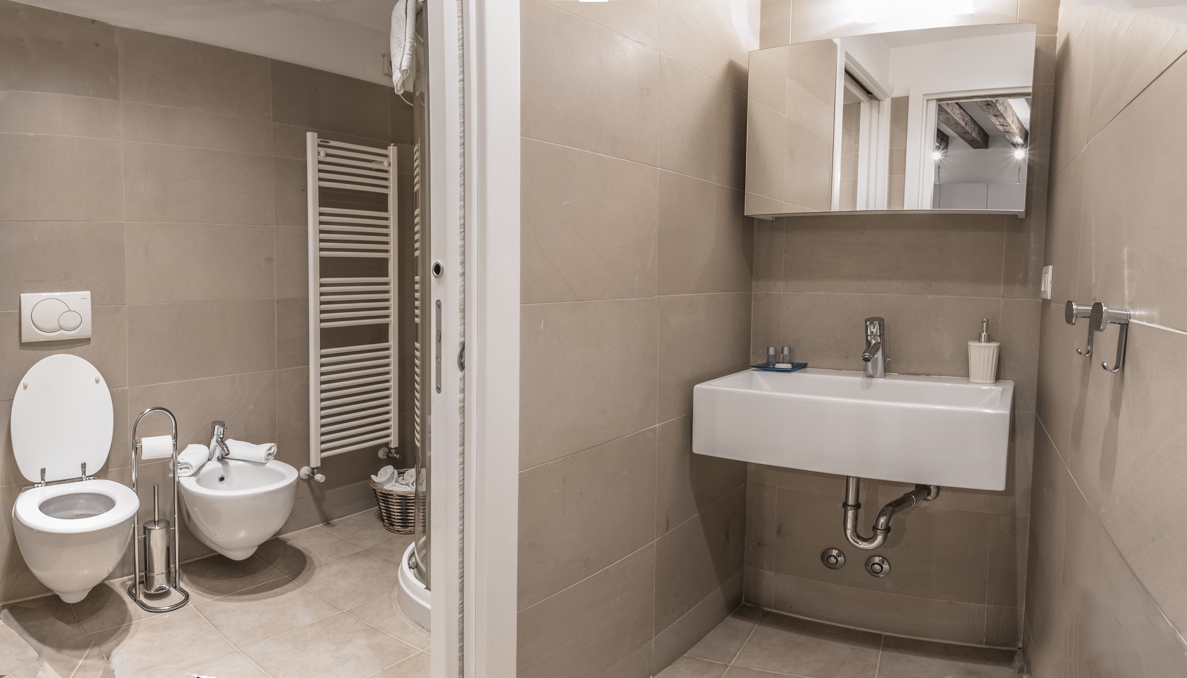 Ein modernes Badezimmer mit Toilette, Bidet und Waschbecken.