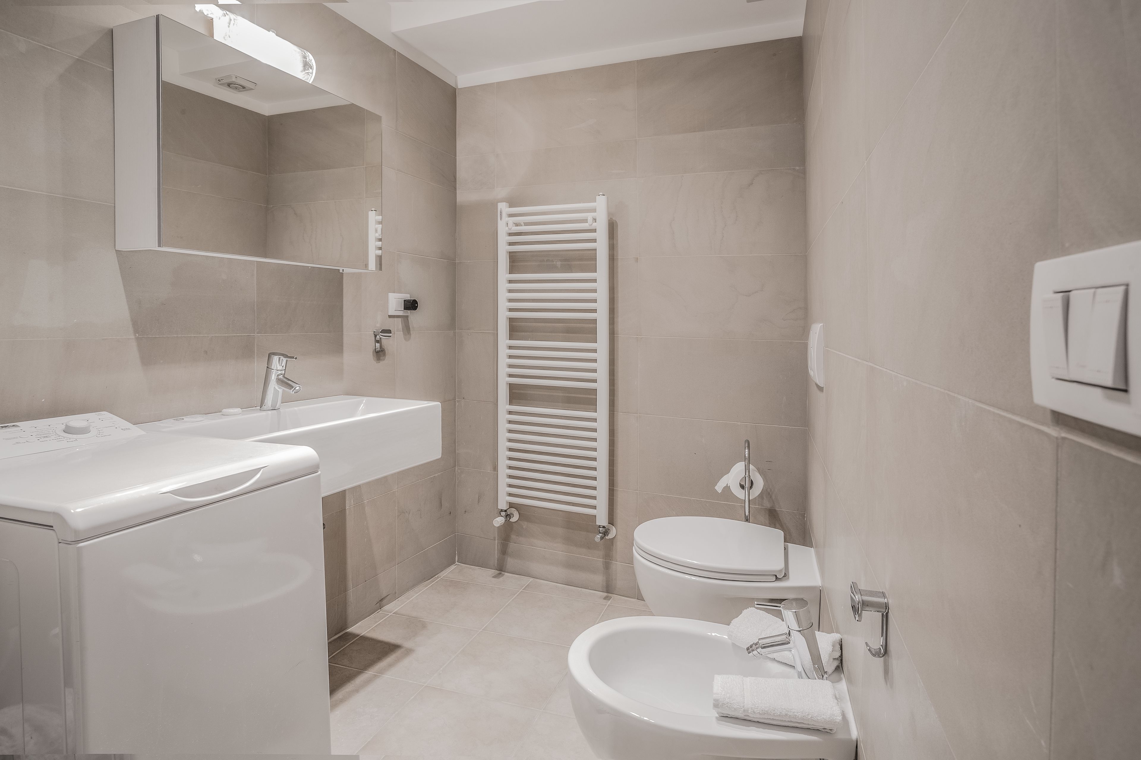 A modern bathroom with a sink, toilet, and bathtub.