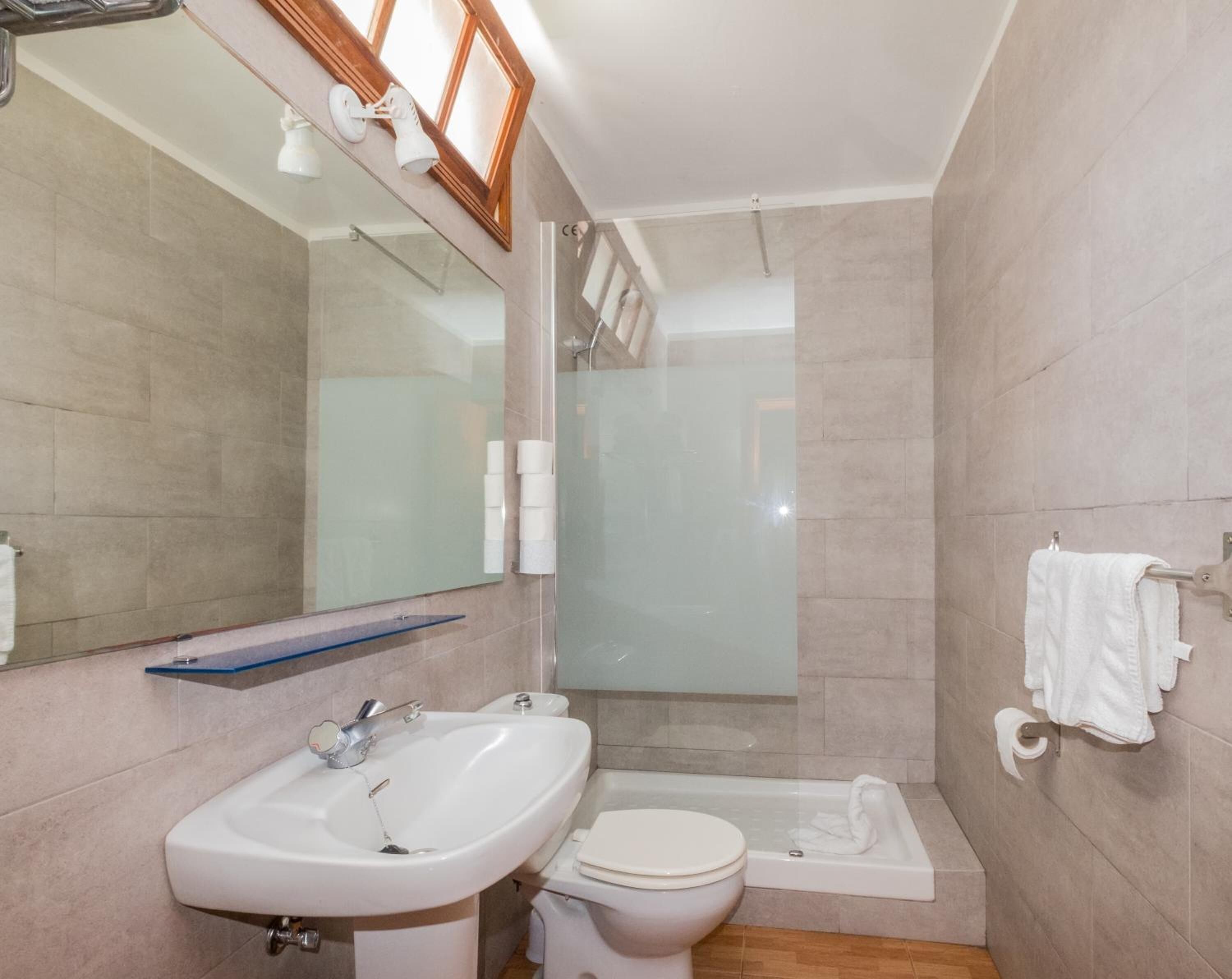 A bathroom with a sink, toilet, and shower.