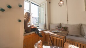 Una habitación acogedora con una mesa de madera, un sofá y una ventana con vistas a la ciudad.