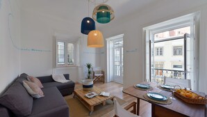 Un salon moderne avec un canapé, une table basse et une table à manger dressée pour un repas.