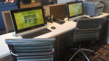 A workspace with two ASUS laptops, a printer, and office chairs.