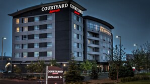 Ein Courtyard Marriott Hotel mit modernem Design, mit mehreren Etagen und einer auffälligen Eingangsschild.