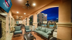 An outdoor patio area with seating, a pool, and a Marriott sign. - TownePlace Suites El Paso Airport (El Paso)