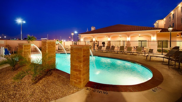 A swimming pool with a 'No Diving' sign, surrounded by lounge chairs and a building with a tiled roof. - TownePlace Suites El Paso Airport (El Paso)
