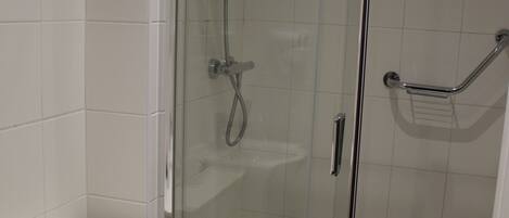 Une salle de bain avec une douche Ă parois de verre, des toilettes et un lavabo.