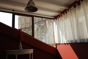 A room with a window overlooking a building with intricate architecture. - Locanda Re Ruggero (Monreale)