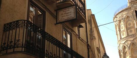 Un edificio de varios pisos con balcones decorados y un letrero que indica un restaurante.