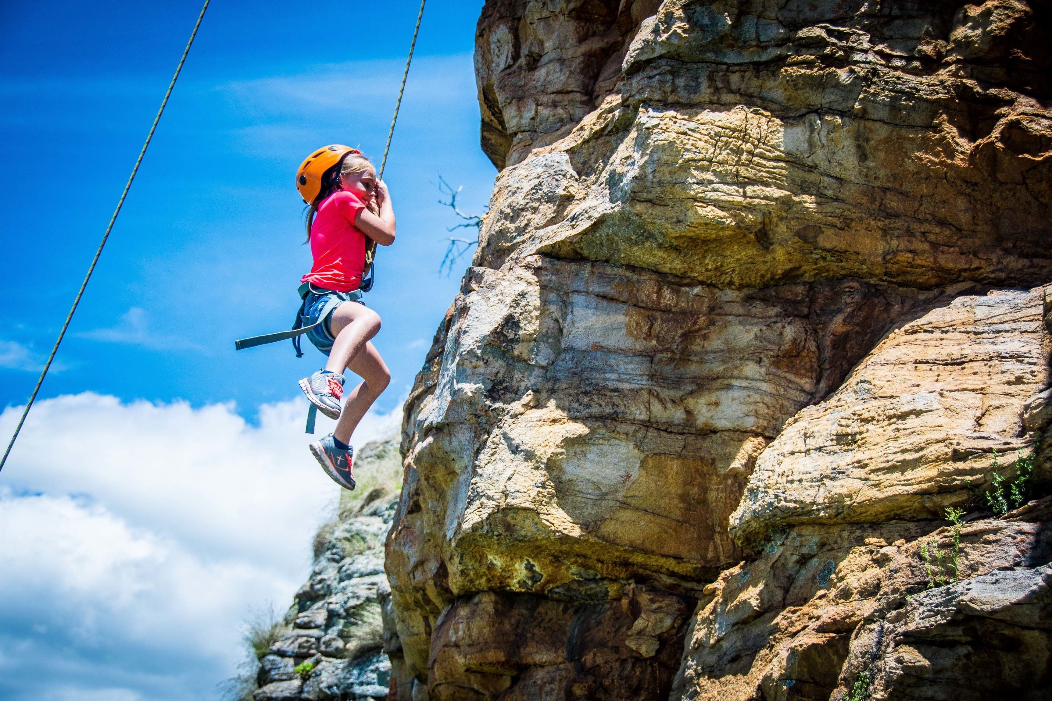 A person rock climbing on a rocky cliff.