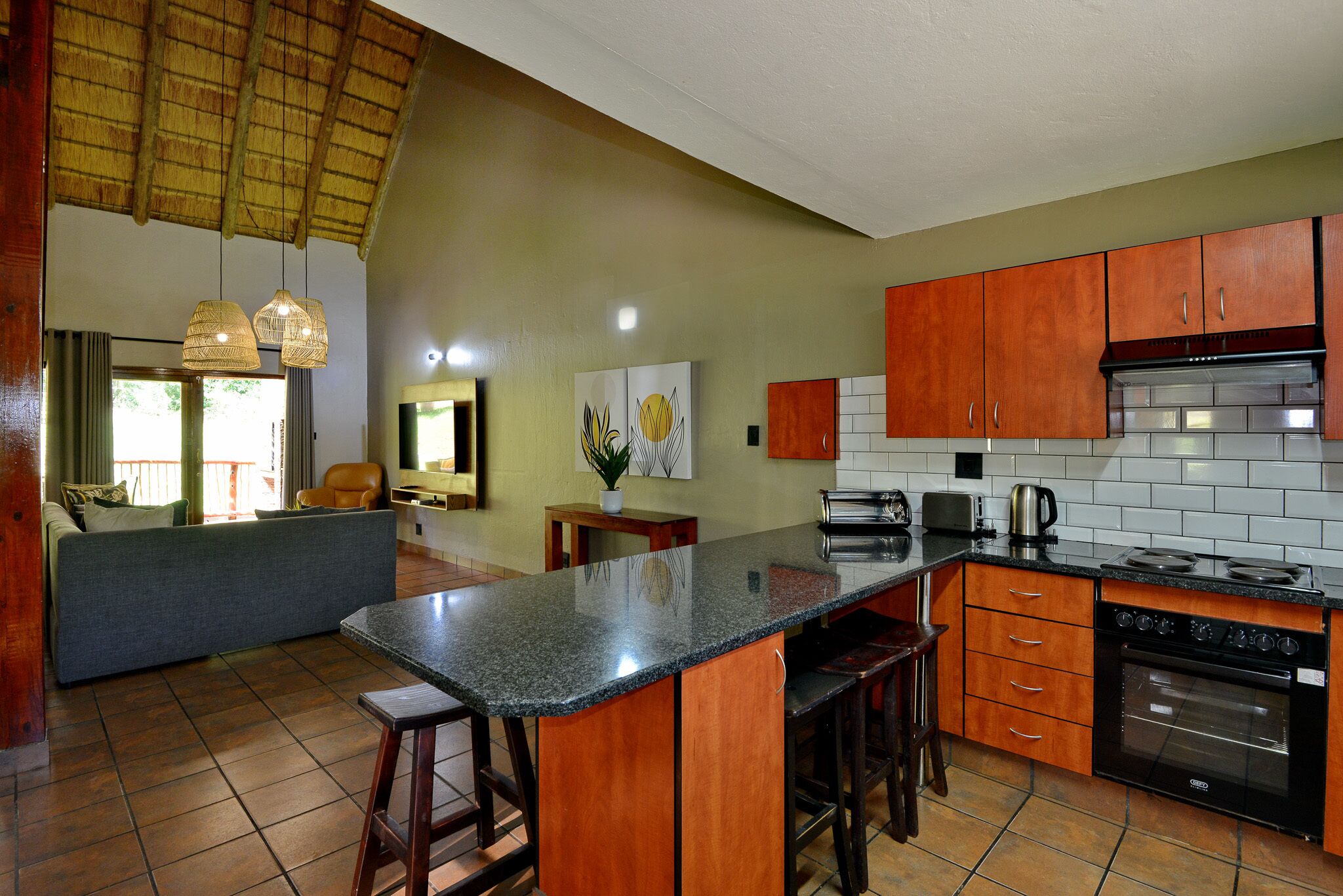 A kitchen with wooden cabinets, a granite countertop, and a built-in oven.