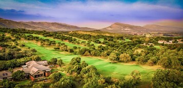 Un campo de golf con una casa al frente.