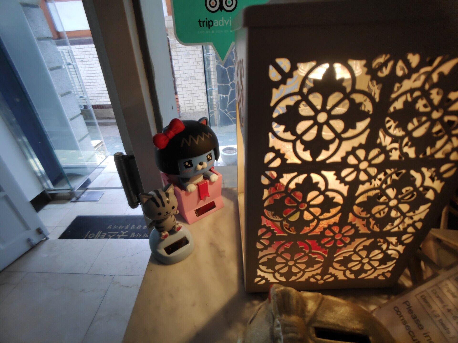 A small figurine of a cat and a character on a counter near a door.