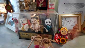 Una exhibición de diversos recuerdos, incluyendo una figurita de gato, un panda y una pequeña botella con tapa roja.