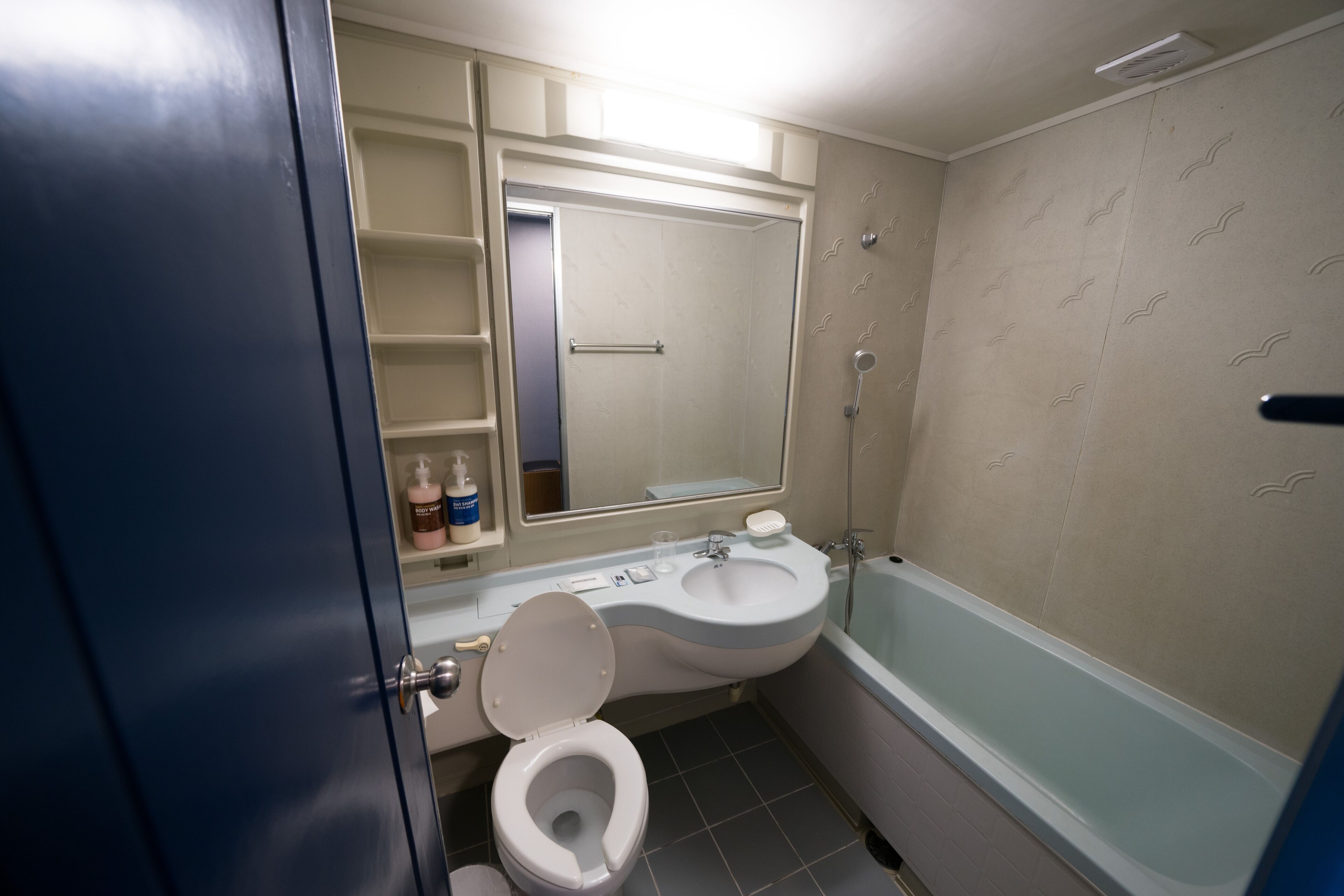 A bathroom with a toilet, sink, and bathtub.
