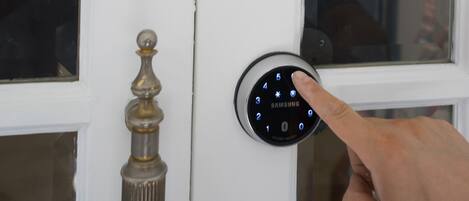 Una puerta moderna con cerradura electrónica de teclado numérico y sensor de huella dactilar.