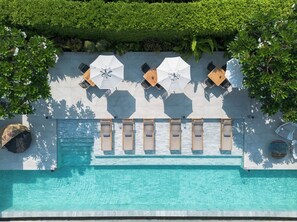 Una piscina al aire libre, tumbonas