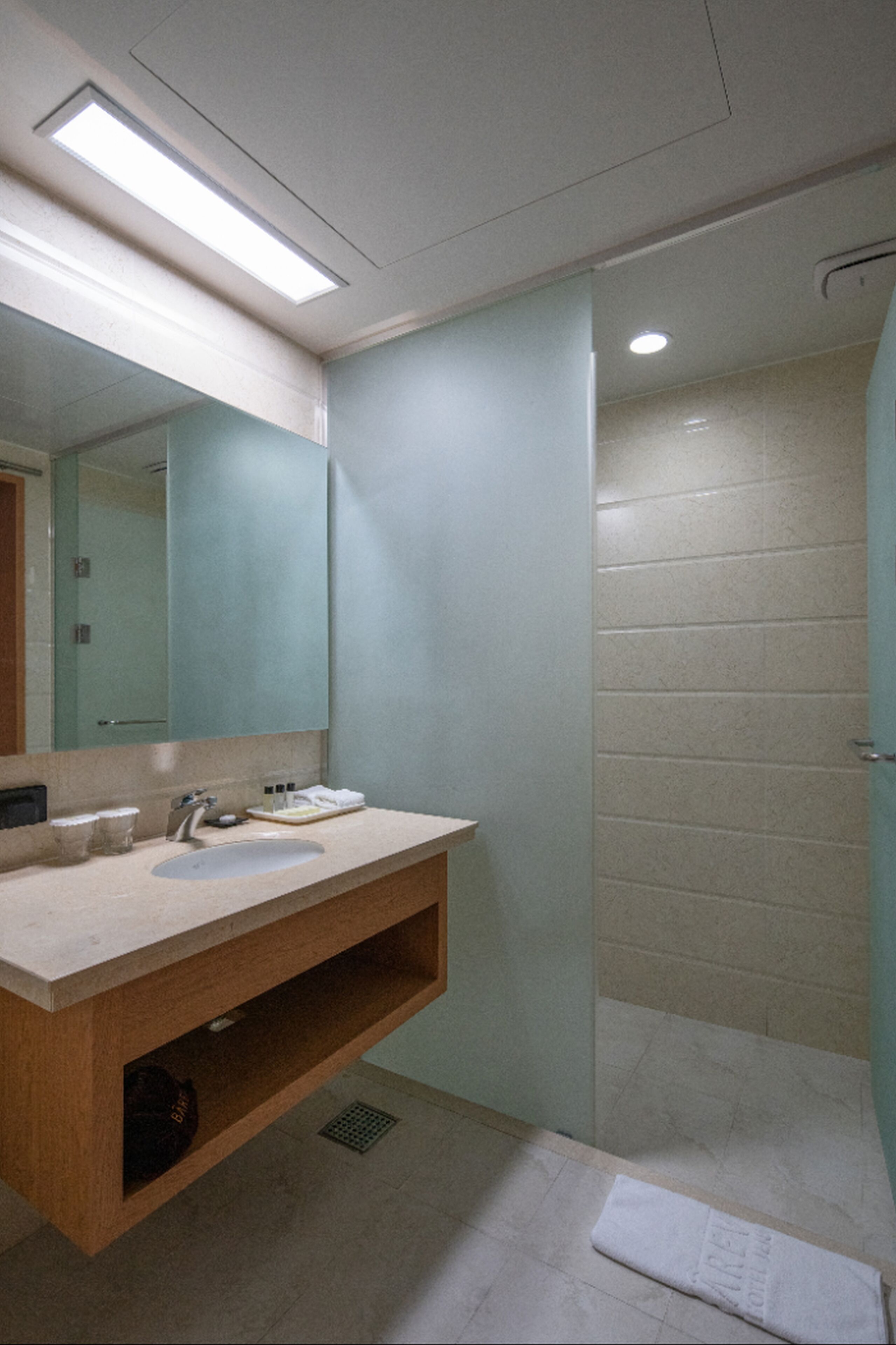 A bathroom with a sink, mirror, and shower.