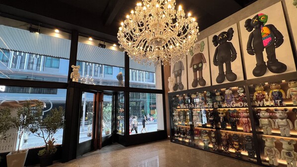 A hotel lobby with a chandelier, large windows, and a display of plush toys. - White Palace Bangkok (Bangkok)