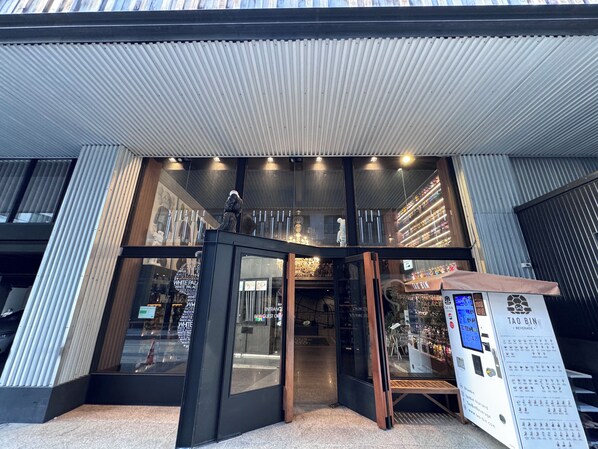 A modern building entrance with glass doors, a black frame, and a signboard. - White Palace Bangkok (Bangkok)
