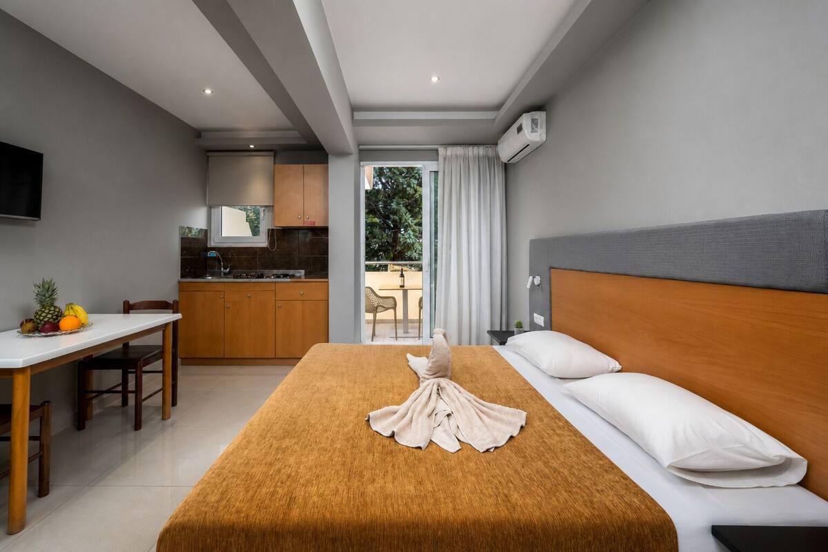 Een hotelkamer met een bed, bureau en kitchenette.